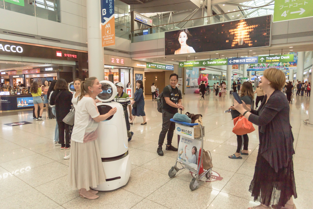 Passengers taking photo with AIRSTAR Passenger Aiding Robot at Incheon airport in South Korea